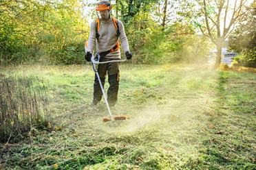 Kosa akumulatorowa STIHL FSA 200 z ergonomicznym oburęcznym uchwytem, widok z przodu na cały produkt, biało-pomarańczowa obudowa