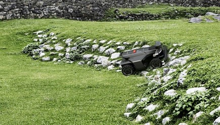 Robot koszący Segway Navimow X430 z napędem na cztery koła i dwoma dyskami tnącymi na dużym trawniku.