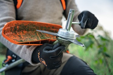 Kosa akumulatorowa STIHL FSA 200 z ergonomicznym oburęcznym uchwytem, widok z przodu na cały produkt, biało-pomarańczowa obudowa